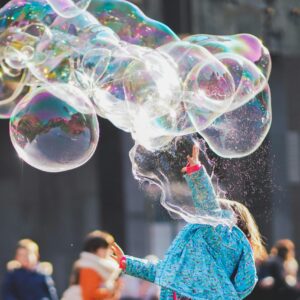 a-child-delights-in-chasing-and-popping-giant-bubbles-in-an-outdoor-setting